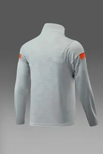 Vue arrière d'un haut d'entraînement de football gris clair à manches longues et détails orange.