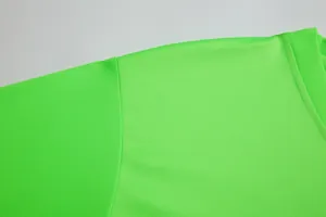 Detailed macro view of neon green soccer jersey showing the breathable mesh fabric texture