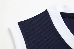 Primo piano del tessuto a rete traspirante di una maglia da basket blu scuro e bianca.