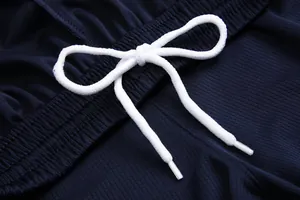 Primo piano del cordoncino bianco e del tessuto a rete traspirante sui pantaloncini blu navy