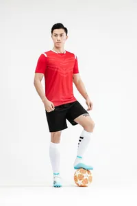 Volledige weergave van een rood voetbaltenue met korte broek en lange sokken op model.