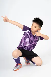 Junge im lila Fußballtrikot mit geometrischem Muster und schwarzen Shorts