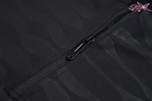Gros plan sur la fermeture éclair noire et le tissu texturé de la veste de survêtement