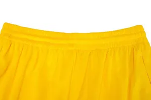 Detailed close-up of yellow basketball shorts waistband with elastic mesh fabric