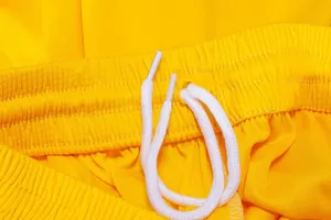 Detailed macro view of the yellow basketball shorts elastic waistband with white drawstring