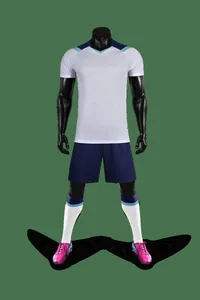 Full soccer kit on mannequin featuring white jersey, navy shorts and pink cleats