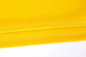 Detailed view of the durable double-stitched hem on a yellow breathable basketball jersey.
