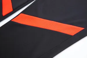 Gros plan détaillé d'un pantalon de football avec bande en maille rouge respirante
