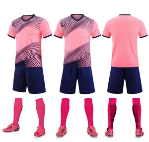 Detail view of pink and navy football kit including jersey, shorts, socks, and cleats