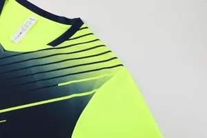 Gros plan sur la texture en mesh respirant d'un maillot de football jaune fluo.
