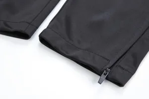 Gros plan d'un pantalon de football noir avec une fermeture éclair à la cheville.