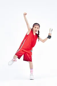 Mädchen im roten Basketball-Uniform-Set feiert mit einer Trophäe, hochwertiges Trikot