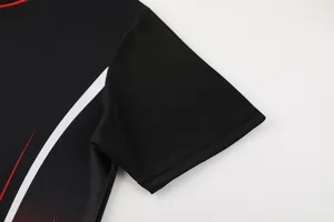 Vue détaillée d'un maillot de football noir respirant avec des graphiques sur la manche