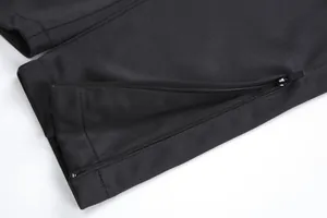 Gros plan d'un pantalon d'entraînement de football noir avec fermeture éclair au bas des jambes.