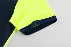 Gros plan du tissu en maille respirant sur la manche du maillot de foot jaune fluo.
