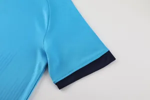Close-up detail of a breathable blue soccer jersey sleeve with a navy blue ribbed cuff