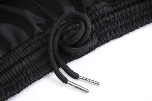 Gros plan du cordon de serrage d'un pantalon de sport noir avec embouts argentés