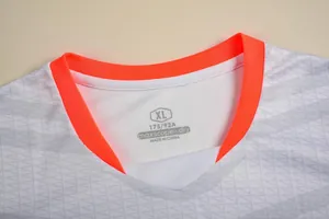 Detail van de halslijn van voetbalshirt met maat XL en oranje geribbelde kraag.