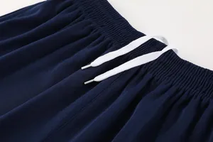 Close-up detail of navy blue soccer shorts elastic waistband with white drawstring cords