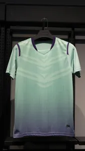 Detail van groen en paars verloop voetbalshirt met V-hals en geometrisch patroon