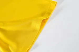 Close-up of yellow breathable mesh fabric and durable stitching on sports team jersey