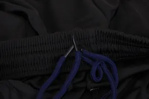 Macro view of sport shorts elastic waistband and blue braided drawstring detail.