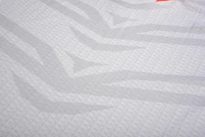 Close-up van ademende voetbalshirtstof met een uniek grijs tijgerstreeppatroon