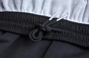 Detalle de la cintura elástica negra con cordón en pantalones cortos de carrera atlética.