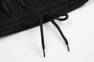 Detalle de la cintura de pantalones cortos deportivos negros con cordón ajustable