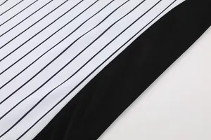 Close-up of professional basketball referee uniform with classic black and white stripes.