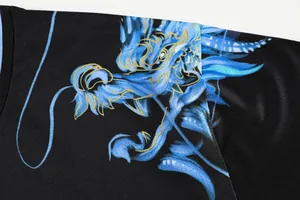 Close-up detail of blue dragon print on breathable black table tennis jersey.
