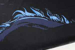 Detailed macro shot of the blue flame pattern on a black quick-dry table tennis sport jersey.