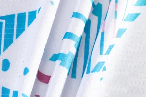Macro view of breathable white mesh fabric with blue graphic print for sports jersey.