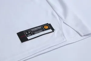 Gros plan de l'ourlet d'un maillot de basket blanc avec une étiquette tissée noire au bas