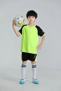 Toma detallada de un niño con un uniforme de fútbol de secado rápido verde neón y negro