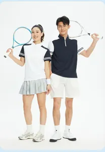 Ein Mann und eine Frau in Sport-Poloshirts mit Tennisschlägern in einer Studioaufnahme.