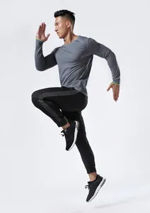 Corredor con camiseta de manga larga gris de secado rápido para deporte y maratón