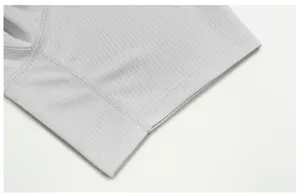 Close-up of breathable mesh fabric and hem stitching on grey quick-dry sports t-shirt