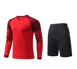 Detailed view of red long-sleeve goalkeeper jersey and padded black shorts set