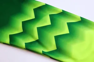 Close-up of green gradient zigzag pattern on breathable goalkeeper jersey fabric.