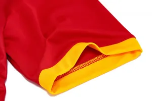 Close-up detail of a quick-dry red dragon boat racing jersey sleeve with a yellow cuff