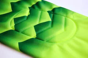 Macro detailed view of neon green padded goalkeeper jersey with high-density fabric texture