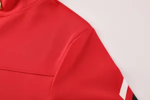 Nahaufnahme der Schulternaht und der gestreiften Stoffstruktur einer roten Badminton-Trainingsjacke.