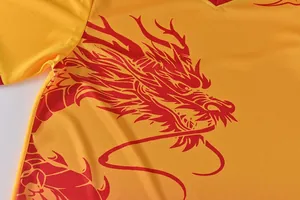 Close-up detail of the vibrant red dragon print on yellow quick-dry dragon boat jersey