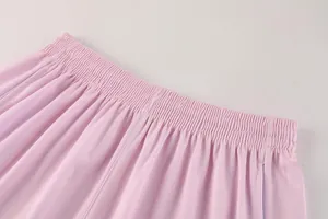 Detailopname van de elastische tailleband en mesh-textuur van roze sportbroekjes