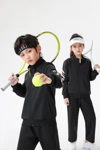Kinder in schwarzen Langarm-Sportanzügen mit Tennisschlägern im weißen Studio-Set