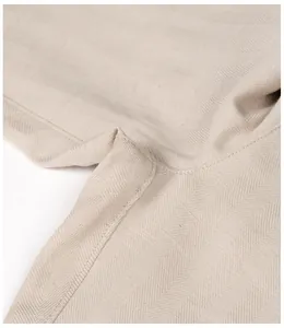 Close-up detail of herringbone texture and stitching on men's breathable beige trousers