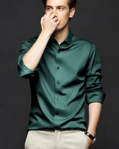 Détail d'une chemise en satin vert émeraude soulignant sa texture soyeuse et son éclat.