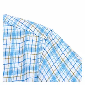 Close-up of the shoulder seam and texture of a blue and white plaid cotton shirt.
