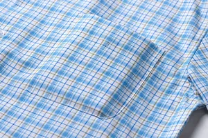 Close-up showing the functional chest pocket detail on a blue plaid short sleeve shirt